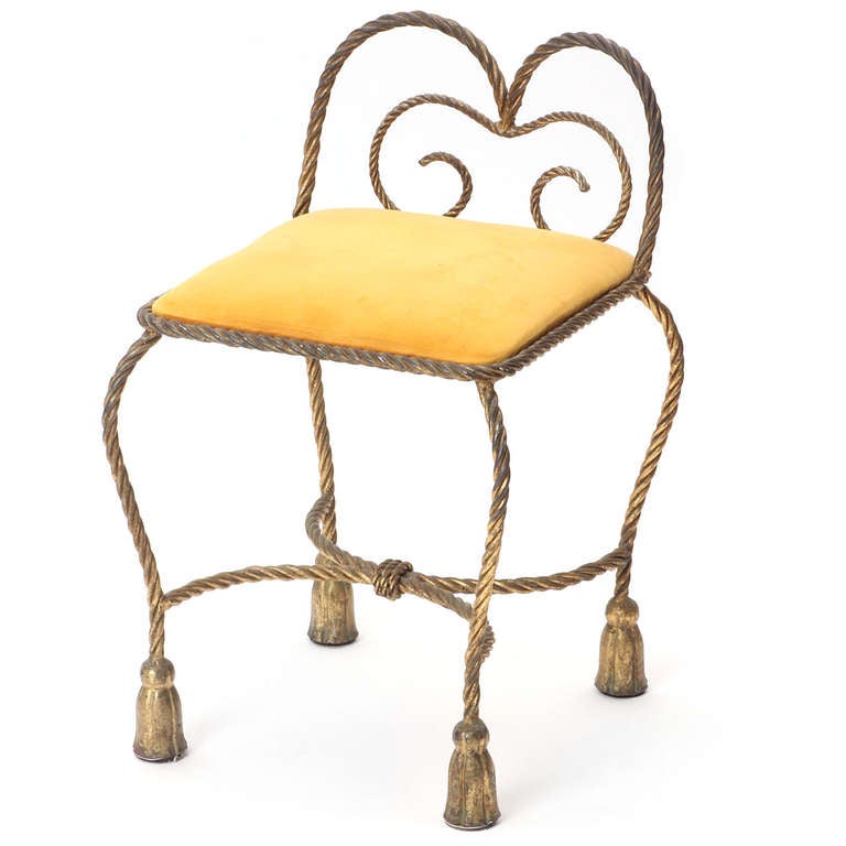 A finely crafted and elegantly composed low stool having a gilded braided iron structure and retaining its original pumpkin velour upholstery.