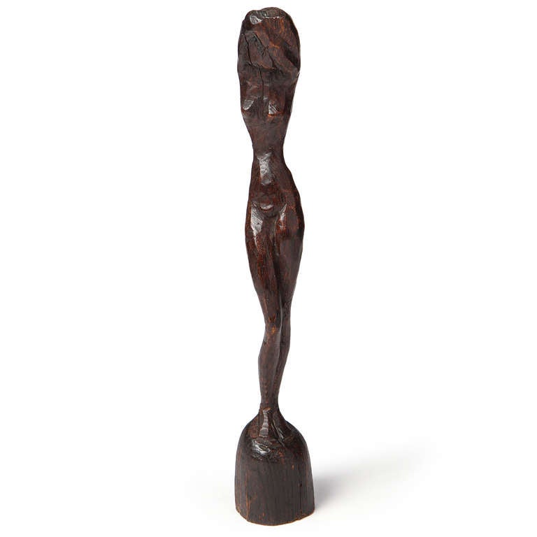 An elegant, yet simple hand-carved statue of a woman with her arms wrapping above her head, executed in richly patinated oak.