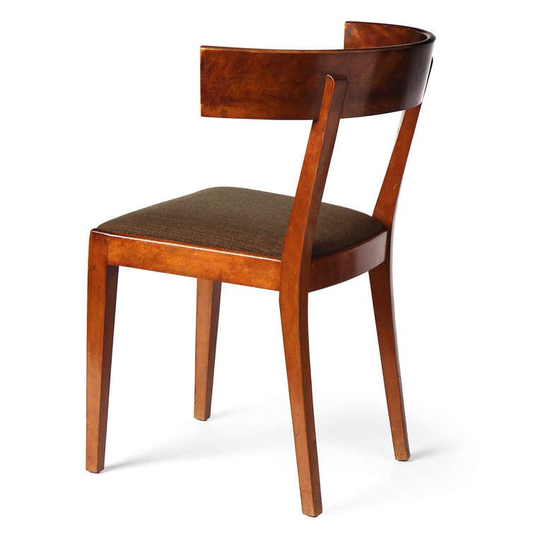 A simple form of the iconic Klismos chair in mahogany with deep curved back and an upholstered seat.