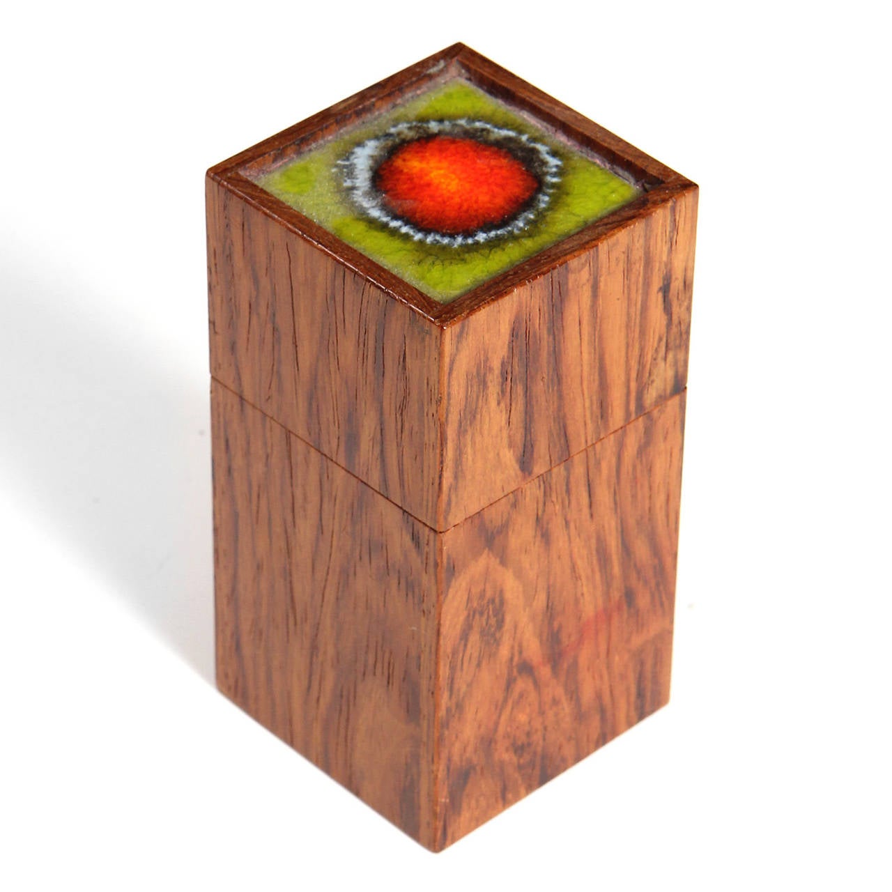 Cette boîte à bijoux en bois de rose est fabriquée de main de maître. Le couvercle est orné d'un carreau de céramique coloré vert et rouge.