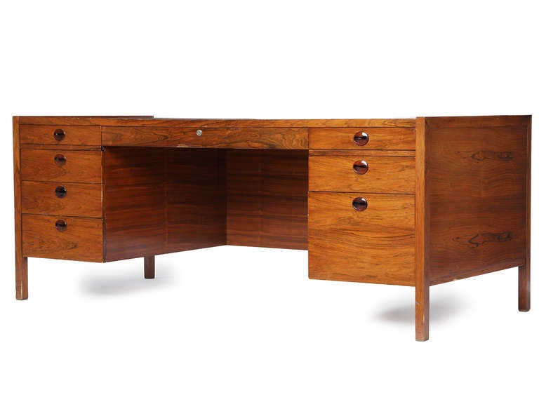 An excellent rosewood desk with eight drawers, including a file drawer, all with shaped rosewood pulls.