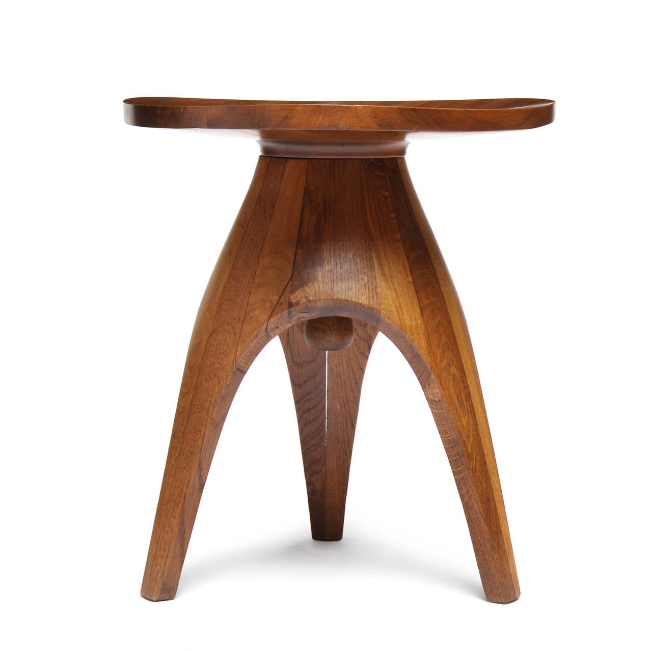 A superbly crafted and sculptural swivel stool having a rounded triangular solid single board teak seat perched on a staved oak three-leg base.