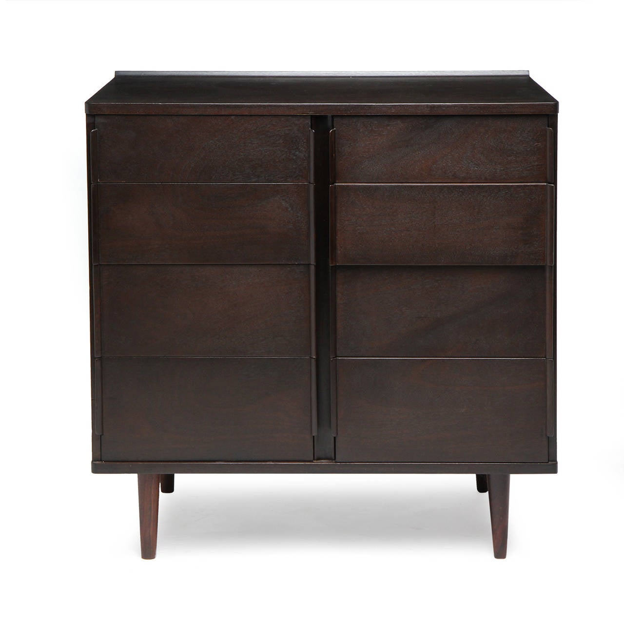 An elegant and well proportioned eight (8) drawer cabinet in ebonized mahogany, having distinctive laminated end pulls, on tapered dowel legs.