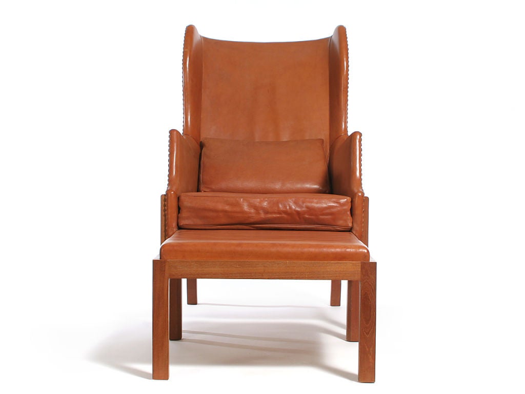 A leather wing back chair and ottoman in the original leather. Seat opens onto ottoman to form lounge chair. Both pieces separate from their exposed Cuban mahogany frames. Designed by Mogens Koch, made by Ivan Schlechter.
chair: 26