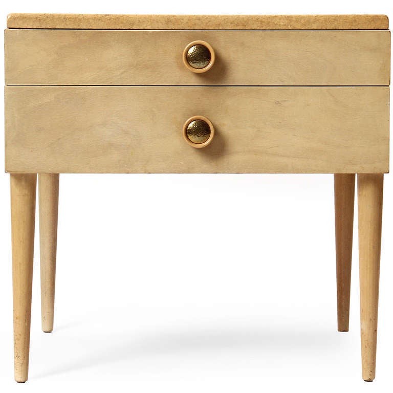 Tapered dowel legs support a bleached mahogany two (2) drawer end table with a cork top, having hammered brass round pulls.
  