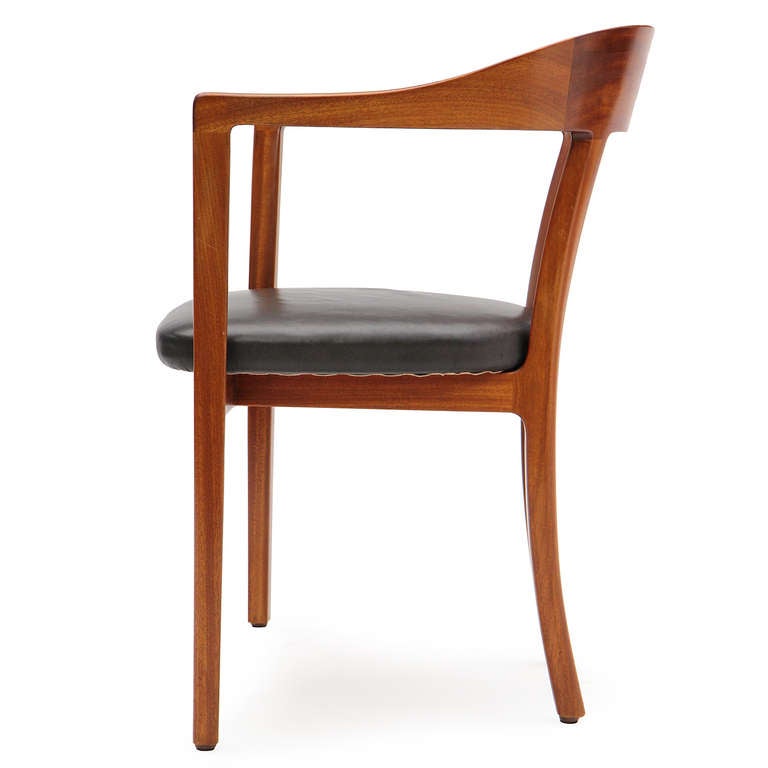 A Scandinavian Modern humpback armchair designed by Ole Wanscher with bookmatched Cuban mahogany, retaining the original black leather upholstery. Made in Denmark by A.J. Iversen, circa 1958.