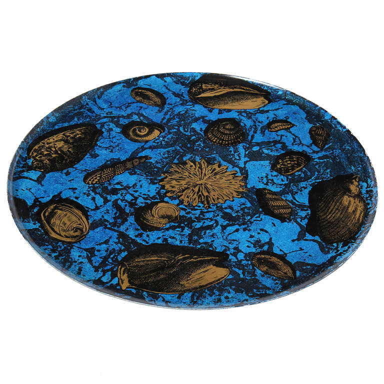A vibrant hand painted platter depicting shells and life at the bottom of the deep blue sea.