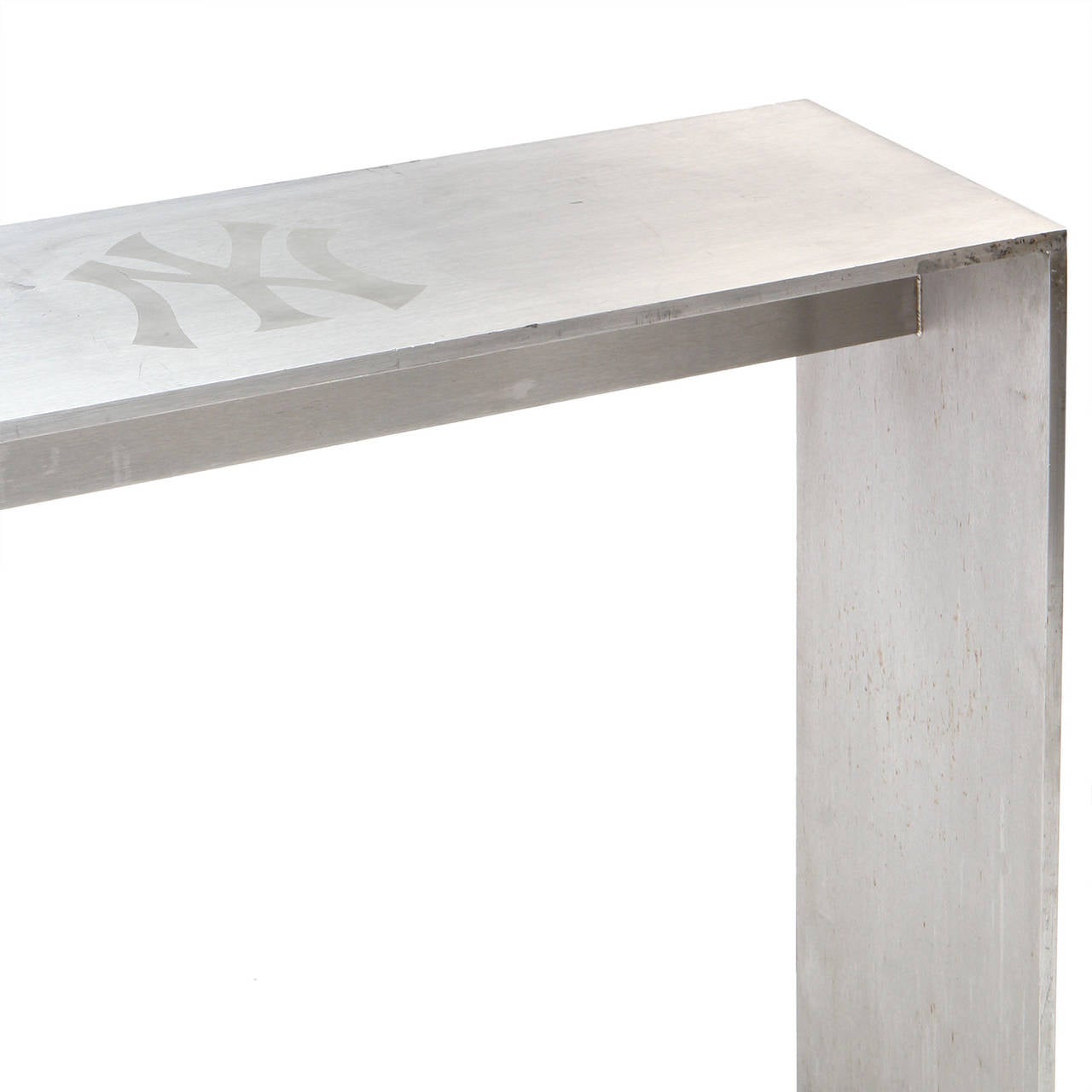 A masterfully fabricated and generously scaled rectilinear polished steel console table from New York's Yankee Stadium having inlaid Yankees logos on the top.