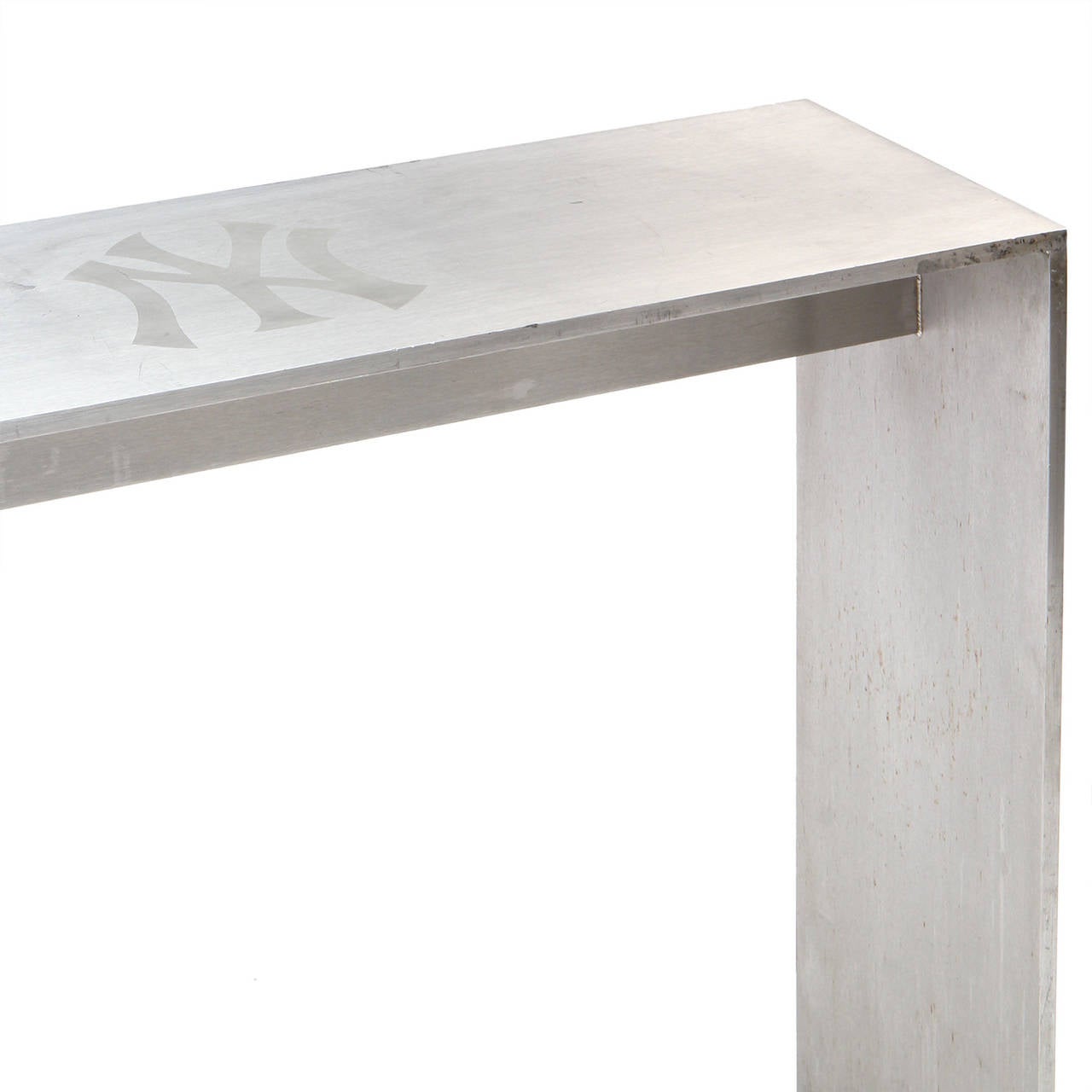 Une table console rectiligne en acier poli, fabriquée de main de maître et de dimensions généreuses, provenant du Yankee Stadium de New York, avec des logos des Yankees incrustés sur le dessus.