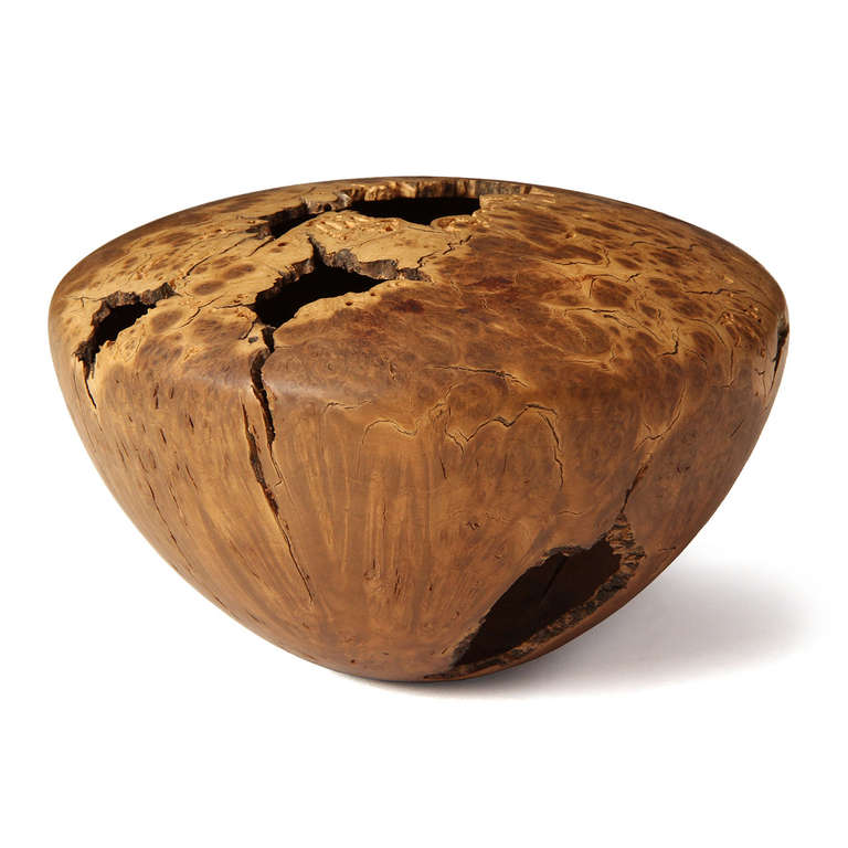 A remarkable turned hollow form vessel with expressive natural cavities, crafted from a singular piece of Manzanita burl. Signed 