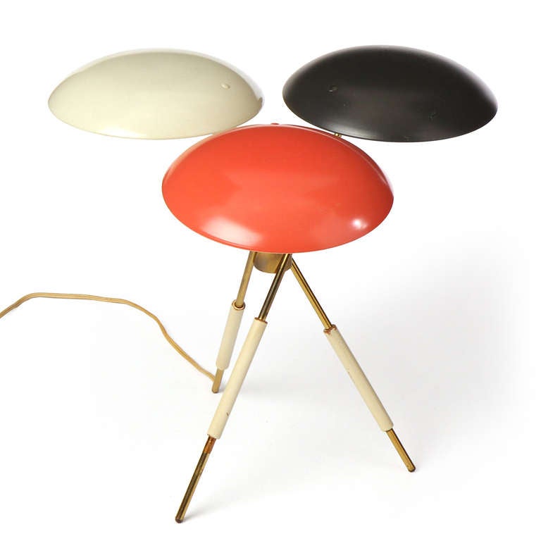 An exceptional table lamp with a brass tripod base supporting three shades of black, red and cream.