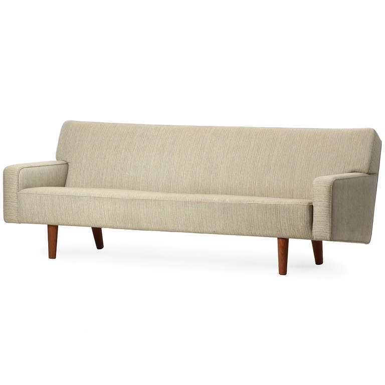 A sculptural, tailored and fully upholstered (and very comfortable) sofa floating on well-scaled turned oak dowel legs and retaining its original cream strie´ 
wool fabric.