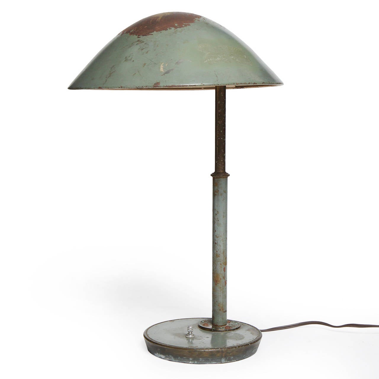 A spare, refined and finely crafted painted Bauhaus era brass table lamp having a domed shade floating above a weighted disc base .