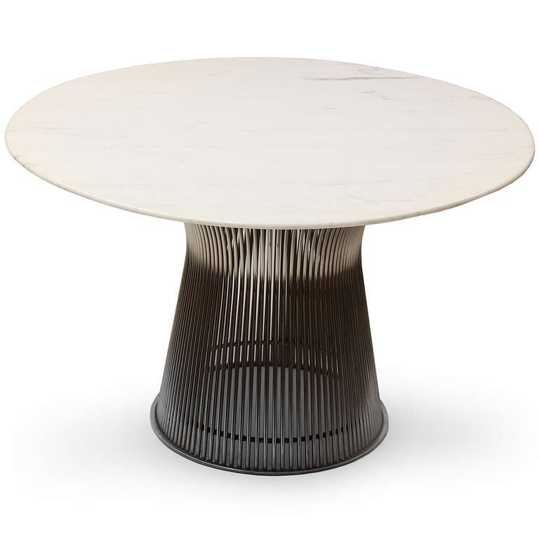Warren Platner's iconic 1960s collection for Knoll explored the expressive possibilities of furniture made from nickel-plated steel rods. This fine and sculptural set consists of six chairs and a table with an extremely unusual oval base and marble