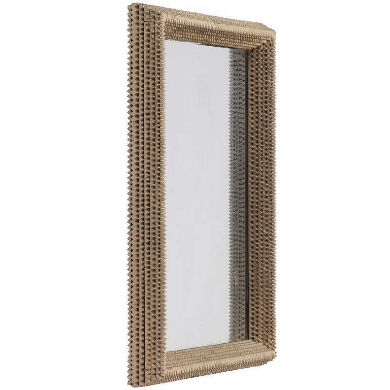A fine and expressive tramp art mirror having a frame of layered zig-zag-cut wood covered with a lustrous silver leafing.