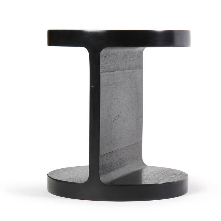 A small scale but very thick steel walled table in the form of a rounded I-Beam.
