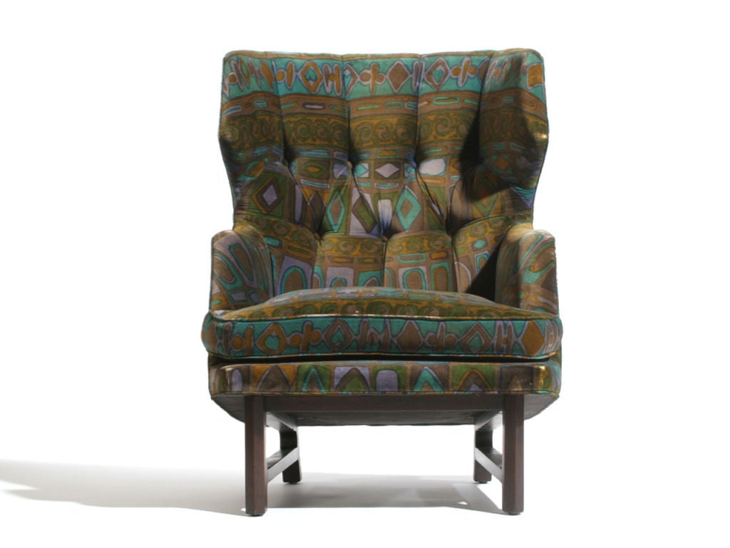 An wing back lounge chair in original Jack Lenor Larsen upholstery on an ebonized mahogany base with matching ottoman. Upholstery recommended, padding firm.