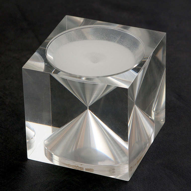 A sculptural and uncommon (only a small quantity was produced in the 1960s) hourglass precisely crafted from clear acrylic with white sand marking fifteen minute intervals.