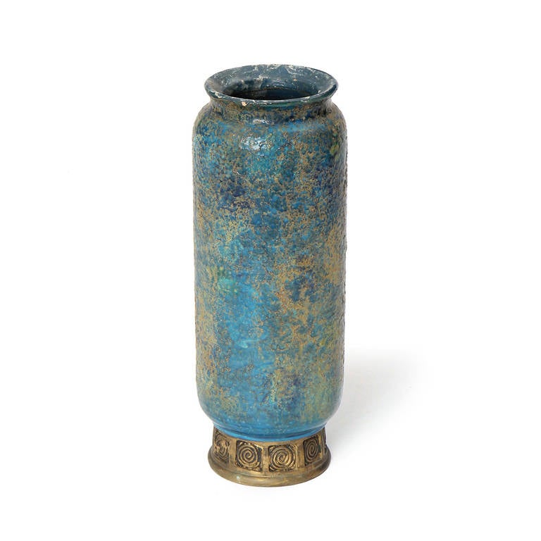 A wonderful ceramic vase with a textured blue glaze with a decorative gold foot.