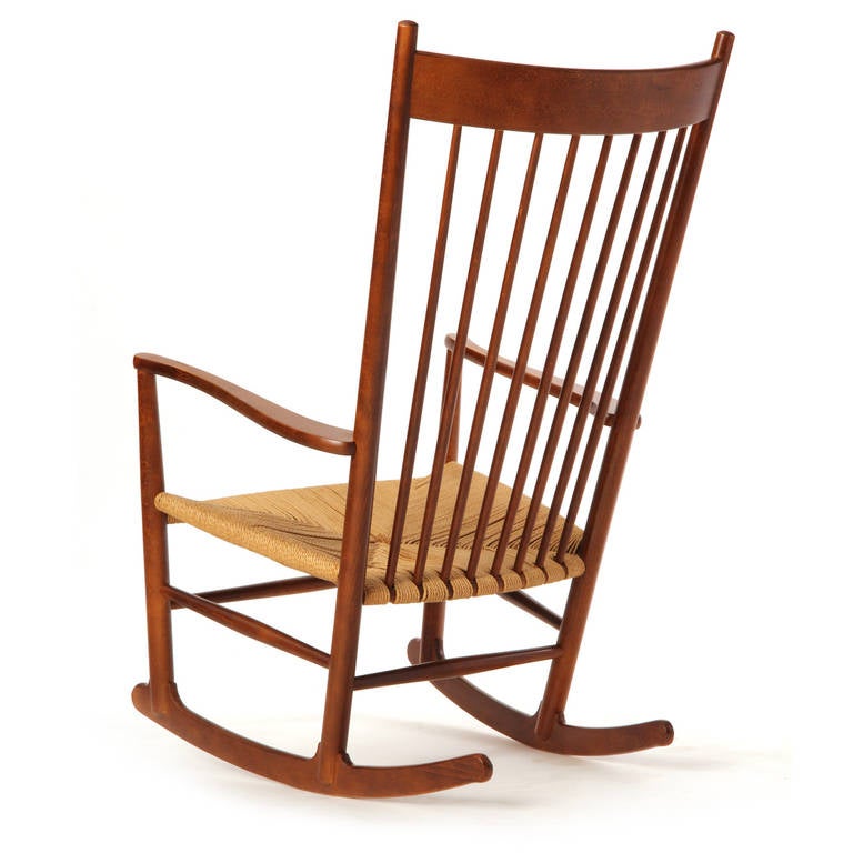 A simple shaker style rocking chair in stained beech with a woven paper cord seat.