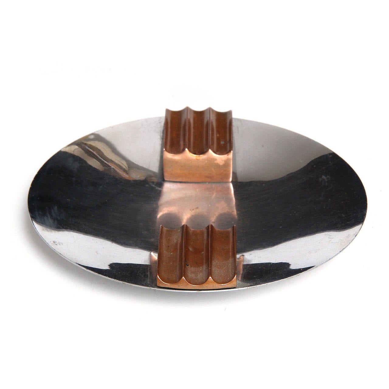 Machine Age modernist ashtray having a pair of fluted and angled copper cigarette rests floating in a shallow chromed steel disc.