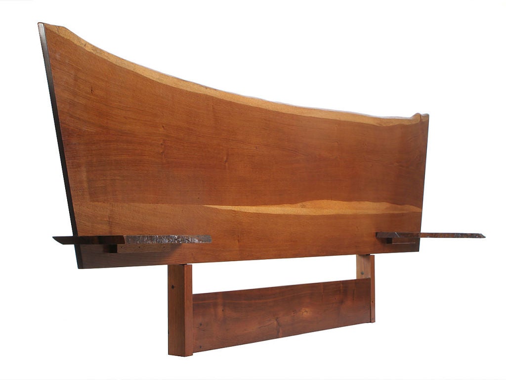A full size, live edge English brown oak headboard with cantilevered walnut shelves.