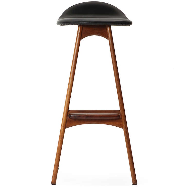 A fine set of sculptural, elegant and comfortable stools crafted of solid rosewood and leather having splayed legs, an organically shaped seat with an upturned back support and a rounded projecting foot rest.