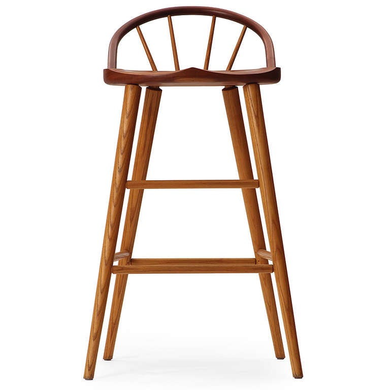 A 'Bowback' stool having a sculpted seat and dowel supported arch back. Hand-crafted of flitch-cut and solid carved cherry, with ash legs and spindles attached with wedged tenons.
