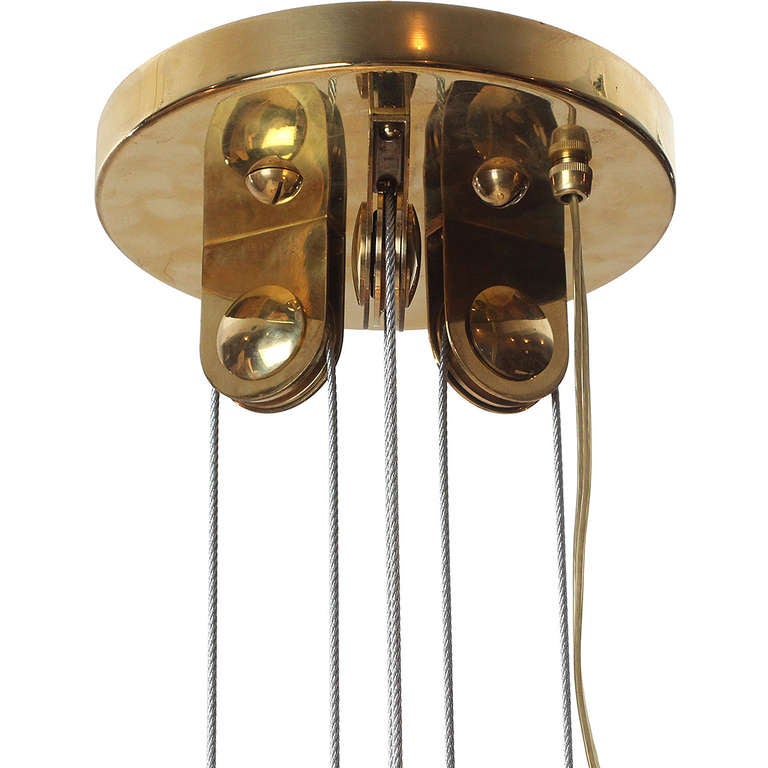 A rare and impeccable polished brass ceiling fixture of uncommonly large dimensions in fine original condition having a scalloped perforated dome fully adjustable on the vertical by means of a massive counterweight and an intelligent pulley system.