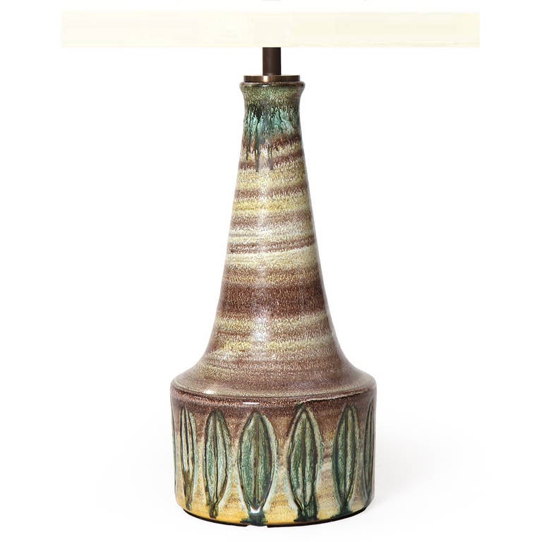 Lampe de table en céramique moderne scandinave de forme conique avec une glaçure ressemblant à une roche sédimentaire et un motif de feuilles. Fabriqué au Danemark, vers les années 1960. 
Hauteur de la base 11.5