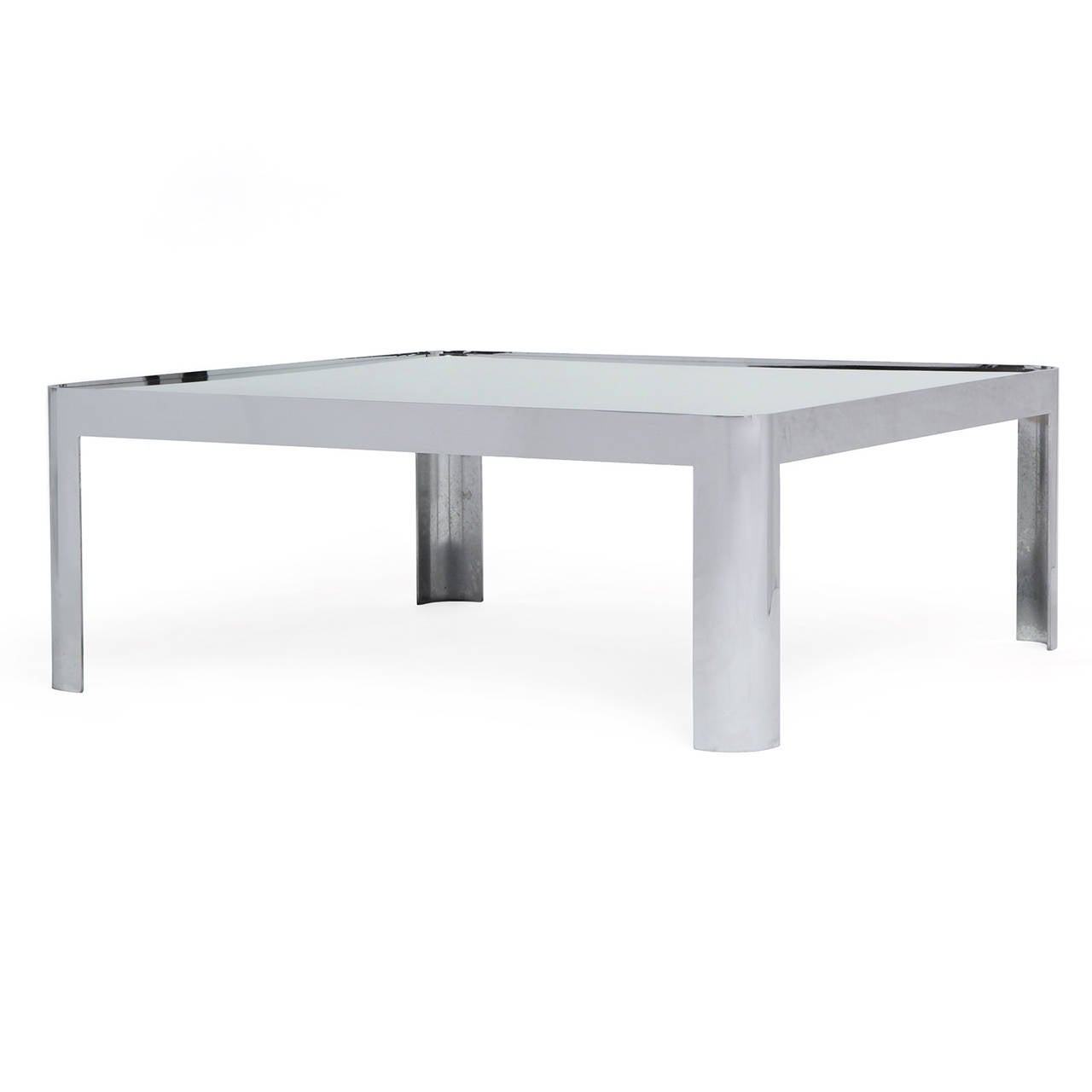 A substantial modernist low table having a one-piece heavy forged polished stainless steel base with rounded corners and legs supporting a floating mirrored glass top.