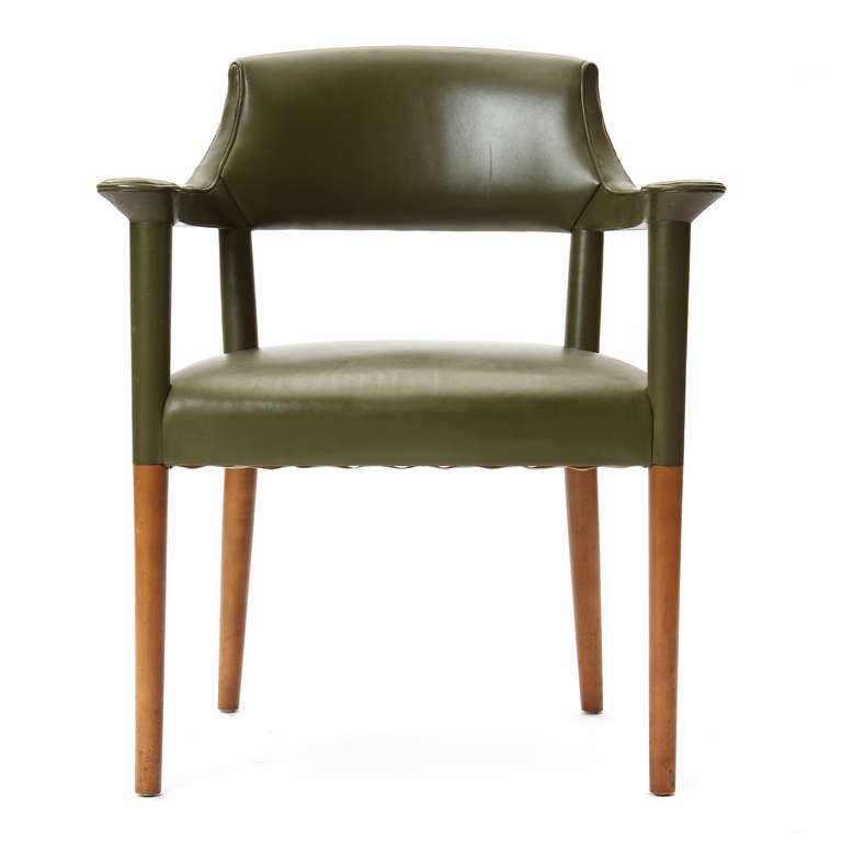 An armchair, with the original rich olive leather upholstery and pale birch tapered dowel legs.