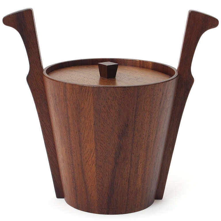A dramatic staved ice bucket in rich teak having flared and carved applied handles.