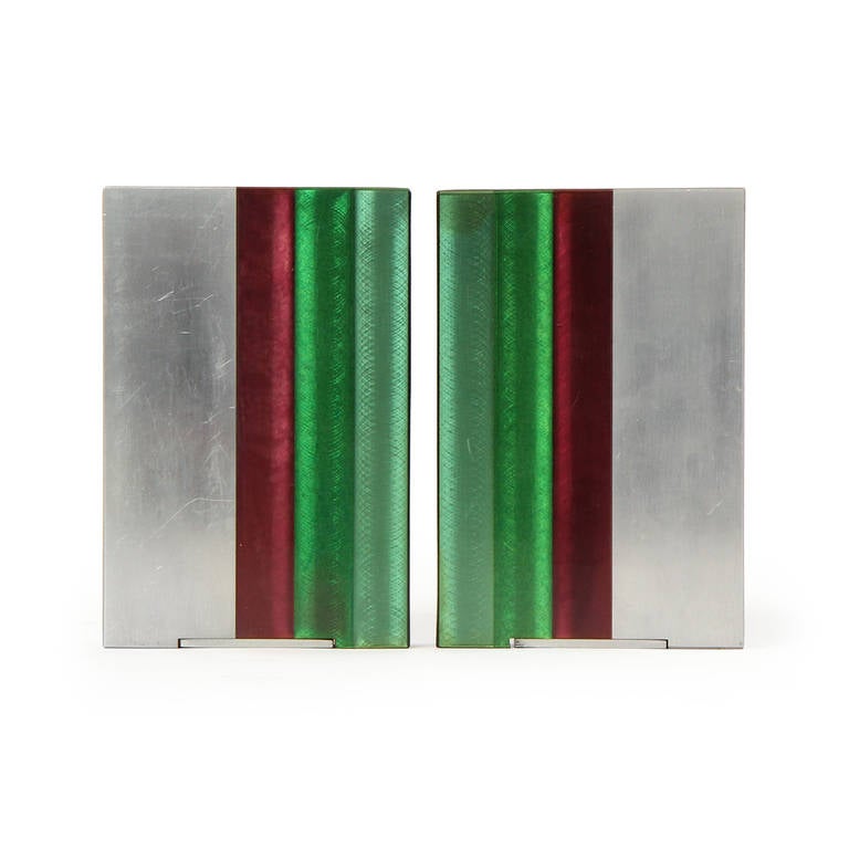 A modernist pair of bookends handcrafted of solid aluminum having expressive inset stripes of colorful polished Lucite.