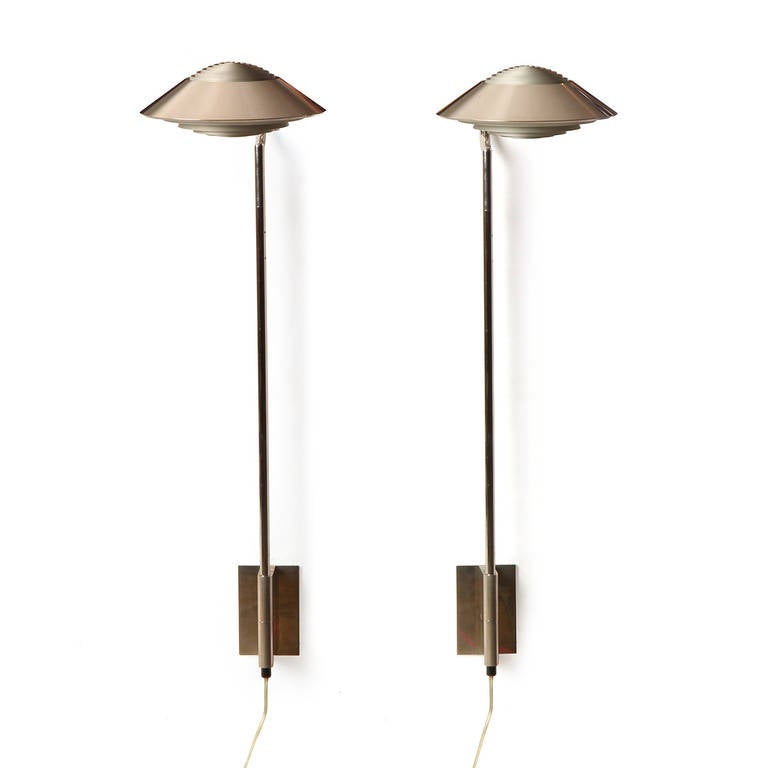 A pair of highly adjustable wall-mounted sconces in nickel and chrome having louvered, swiveling shades. These sconces may also be height-adjusted.