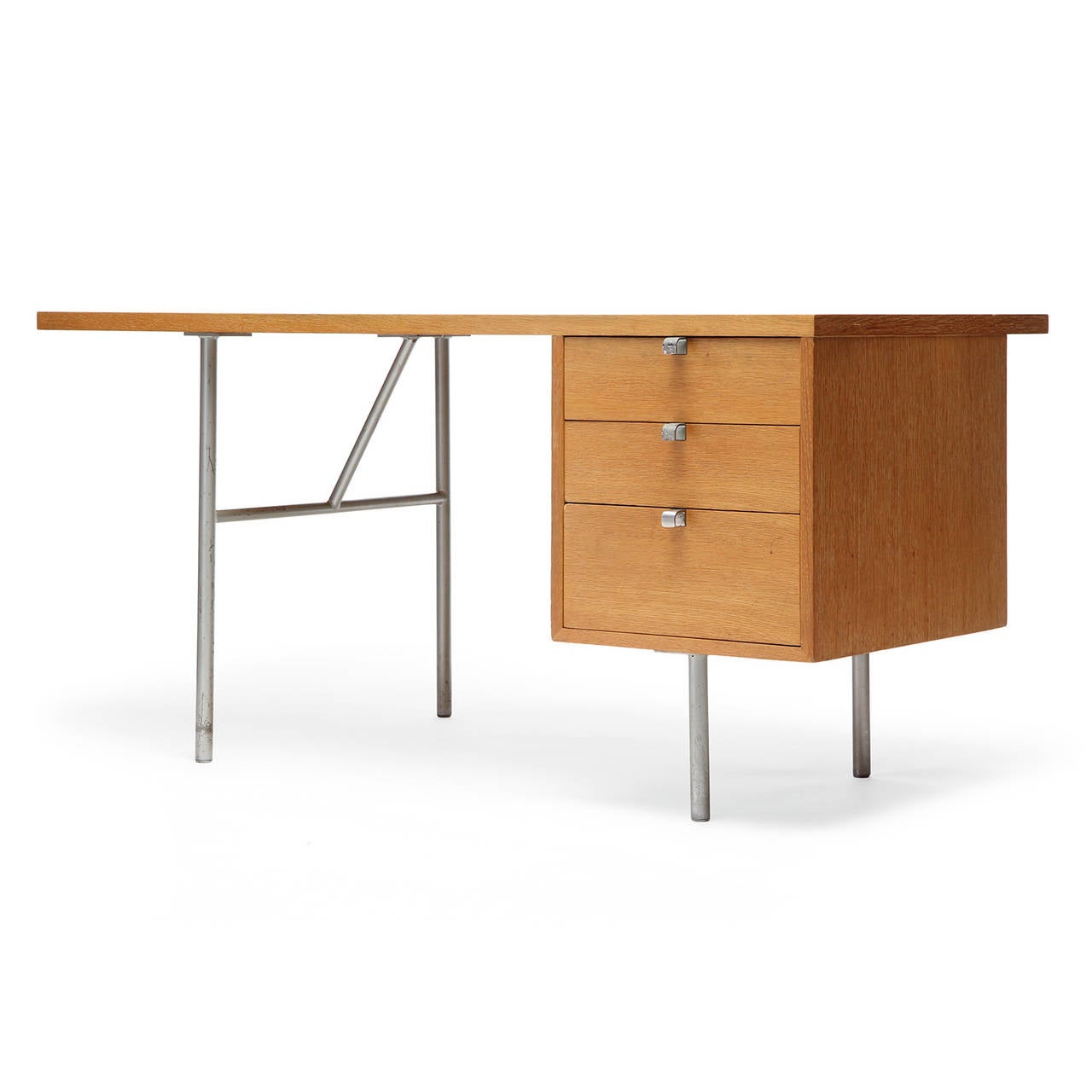 A simple and finely proportioned rectilinear work desk in oak having a bank of three drawers and an architectural support structure of tubular steel.