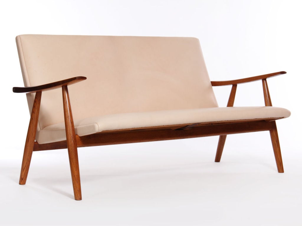 Natural leather upholstered settee on an oak frame. Design by Hans Wegner made by Getama