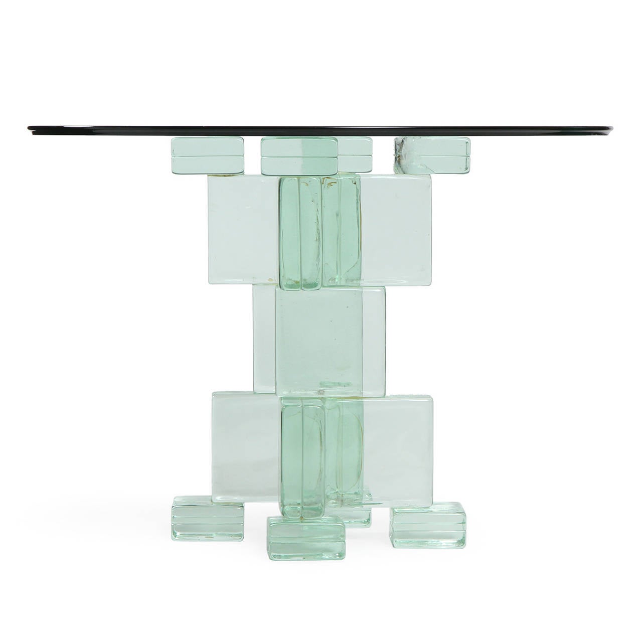 An unusual and masterfully crafted pedestal table having an intricate geometric base fashioned of interconnected square glass blocks that support a floating circular glass top.