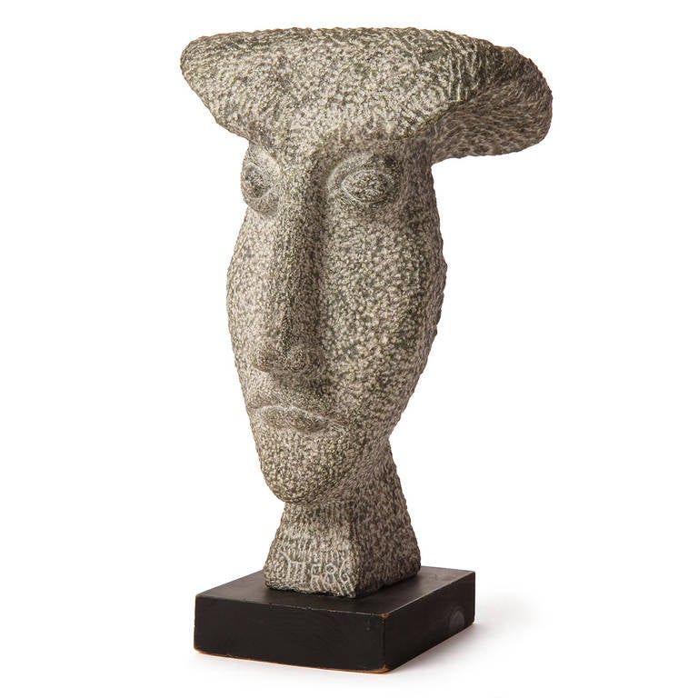 A well-scaled and expressive abstracted bust made of carved and etched granite and mounted on an ebonized wooden base. Signed MF88.