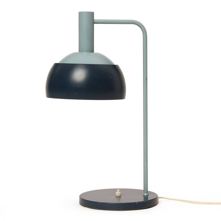 An elegant and finely scaled desk lamp having a hemispheric shade floating above a disc base. The lamp retains its original eggshell and deep blue paint.