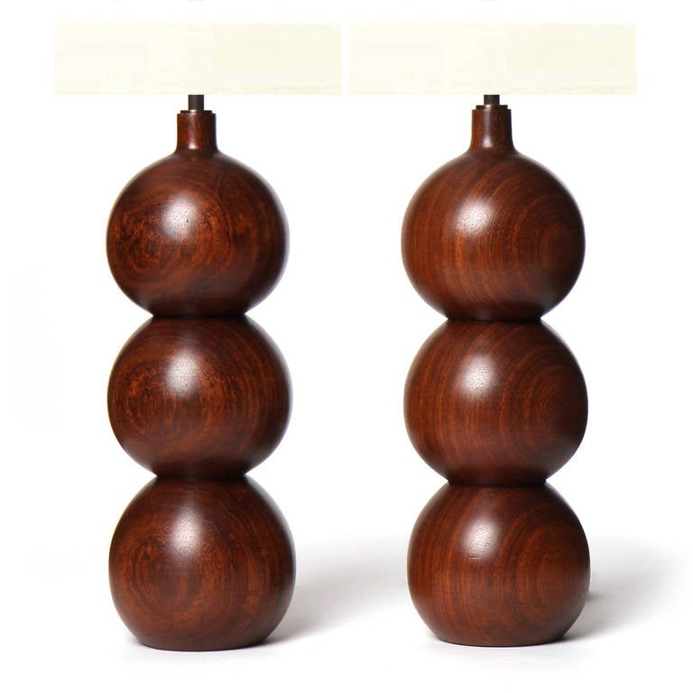 A sinuous pair of masterfully turned stacked sphere table lamps made of actively grained walnut.