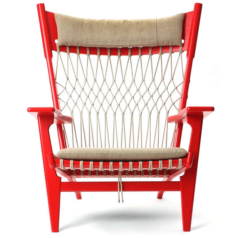 A dynamic and generously scaled red lacquered armchair having a beautifully fitted frame with paddle arms and flaring legs, the upholstery crafted of diamond-patterned flag halyard and natural linen.