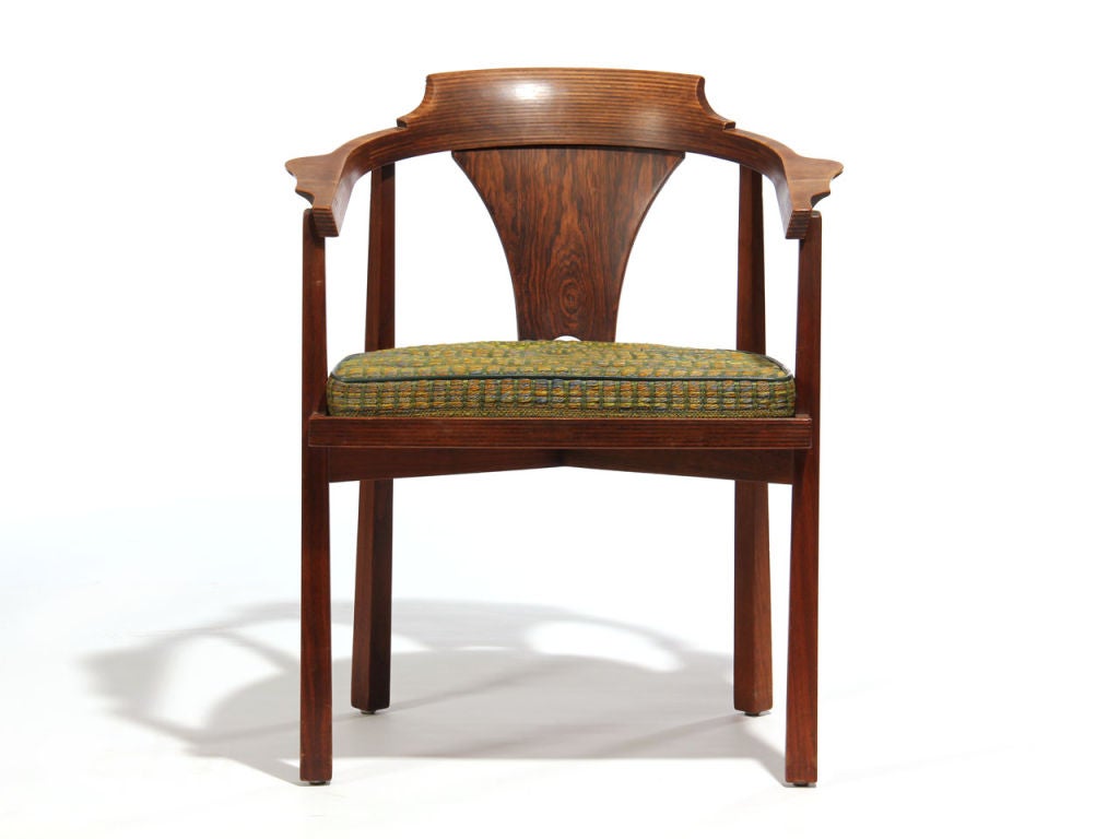 A first production rare walnut laminated and sculpted horseshoe back dining chair, with a flared rosewood backplate and a loose button tufted patterned seat cushion.