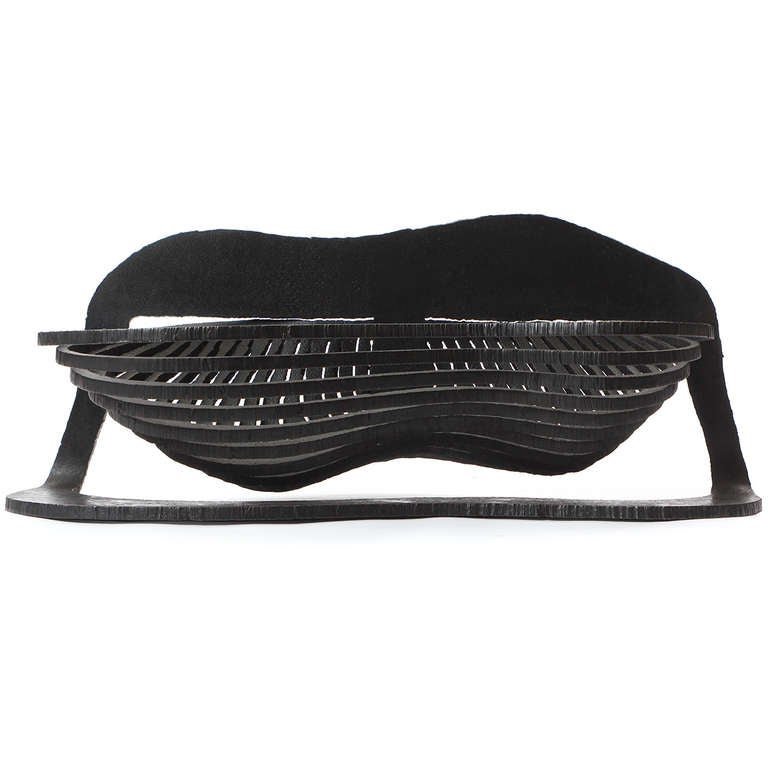 A sculptural, artist made self-standing fire or coal basket cut and shaped from a single sheet of blackened steel.