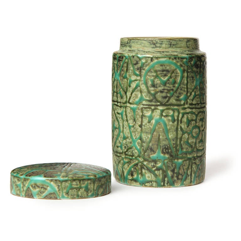 A nicely modeled lidded stoneware vessel in matte green tones having an expressive all-over abstract decoration.