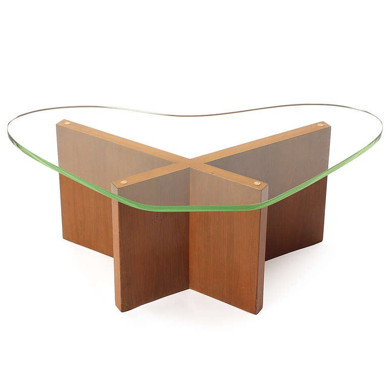 A striking and well-crafted X-based low table in walnut having a biomorphic boomerang-shaped glass top.