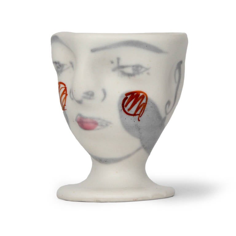 A beautifully crafted artist-signed ceramic footed sculpture of a head, having finely-painted and drawn decoration over a soft cream matte glaze.