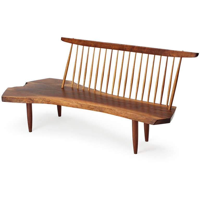A fine and exciting example of George Nakashima's iconic Conoid bench in highly figured black walnut, having a dramatic seat fashioned from a single slab with a rosewood butterfly and free and boldly sculpted edges.