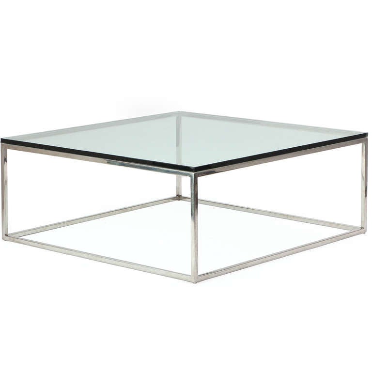 A well-crafted and sleek rectilinear minimalist low table made of square-gauge steel with a thick beveled-edge glass top.