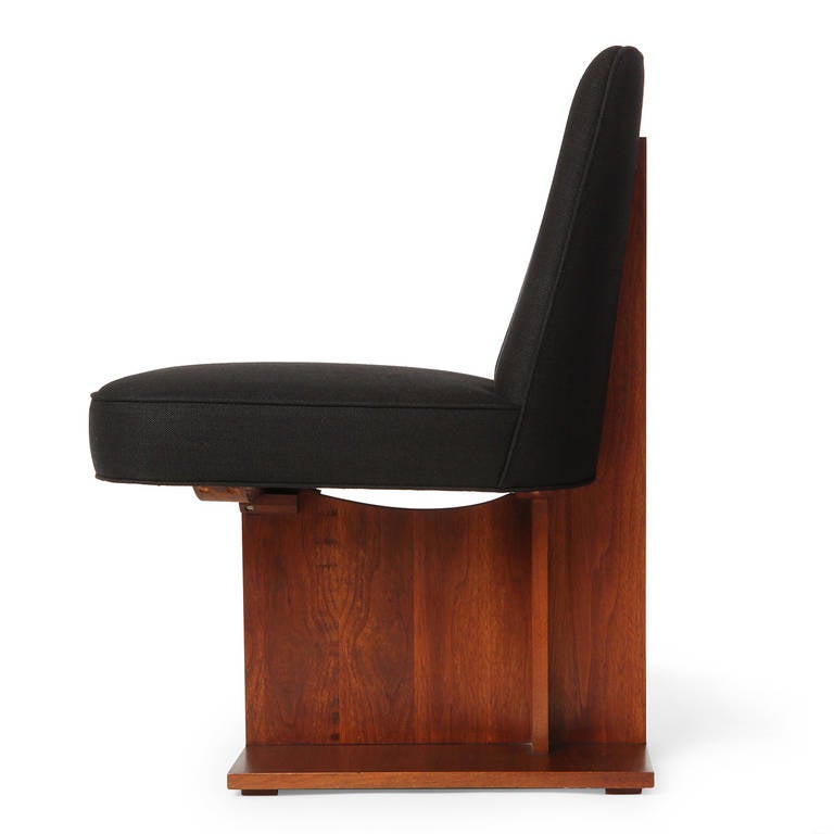 A rare pedestal chair having a striking rectilinear architectural frame made of solid rosewood, supporting a floating armless seat covered in a rich black linen.